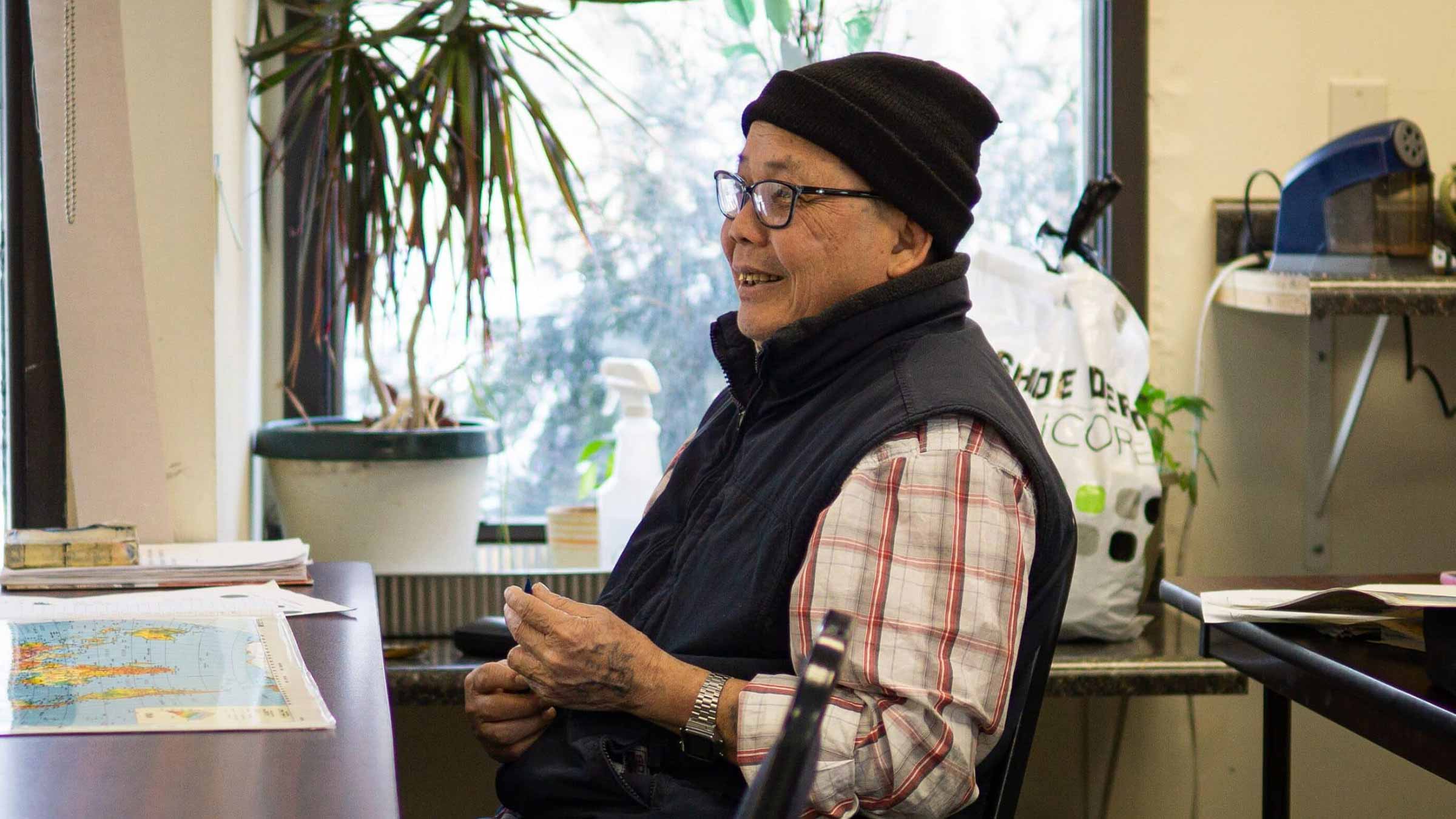 A woman sits at her desk with a window behind her