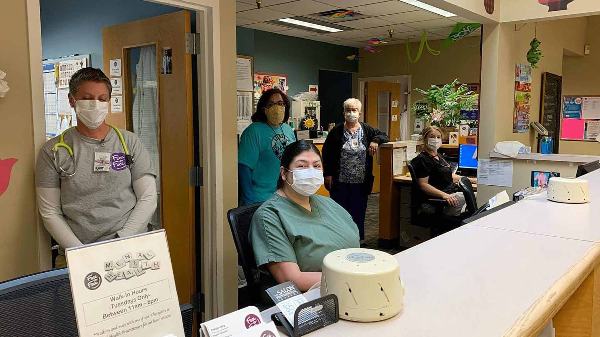 A group of healthcare workers gather together at their office