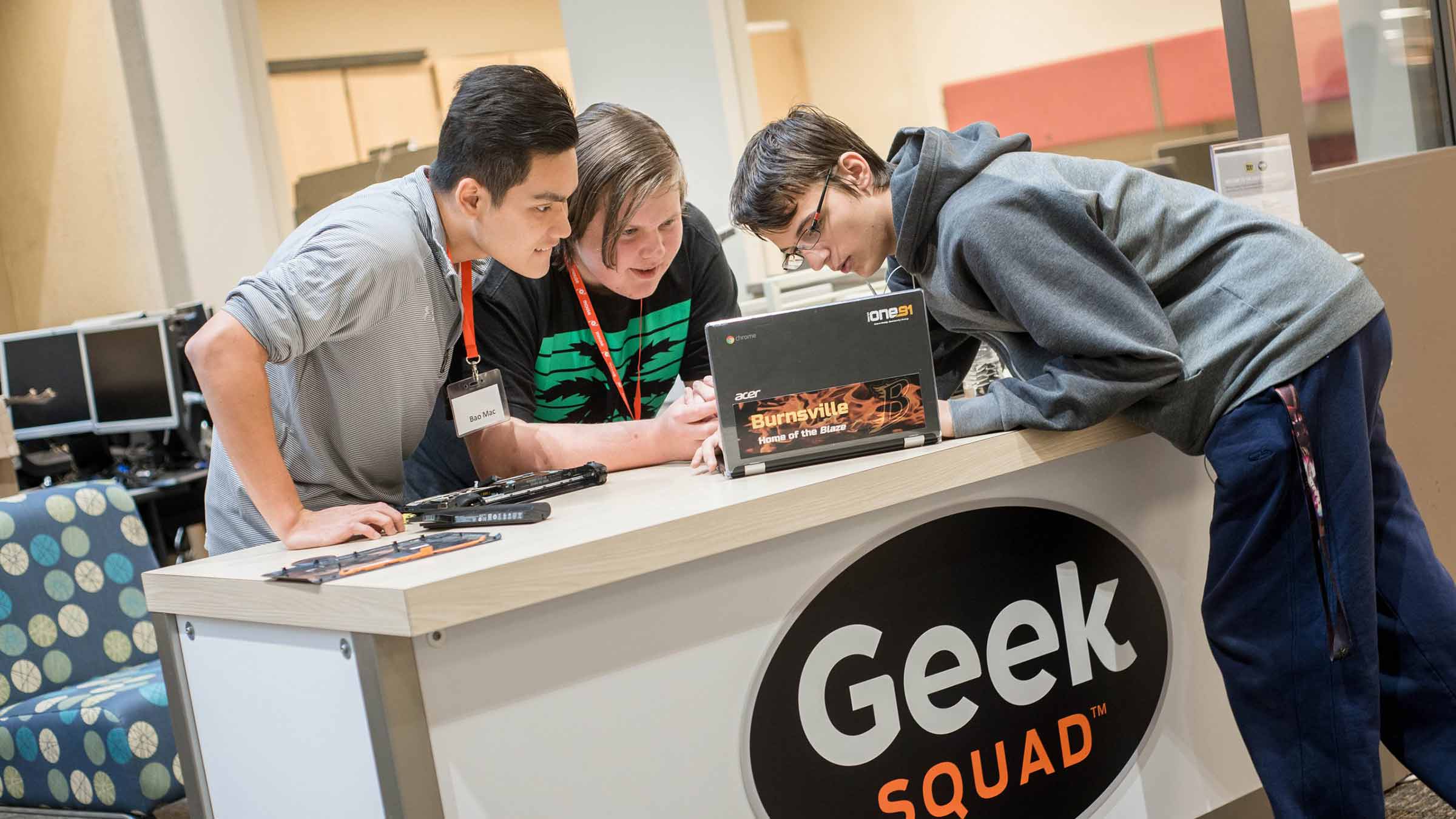 A group of Career Academies students look at a computer together