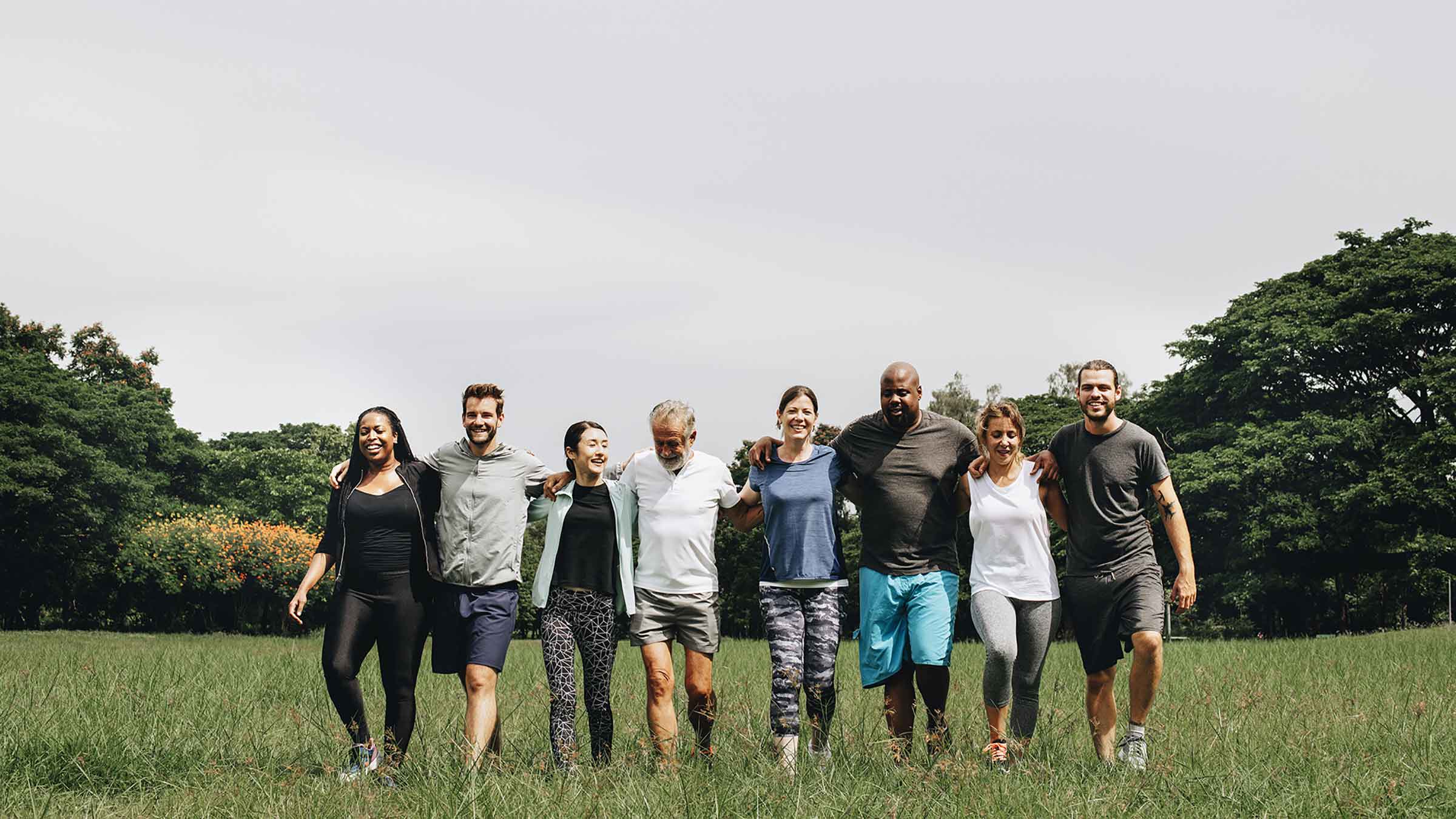 Group of people hugging and walking with each other in the park