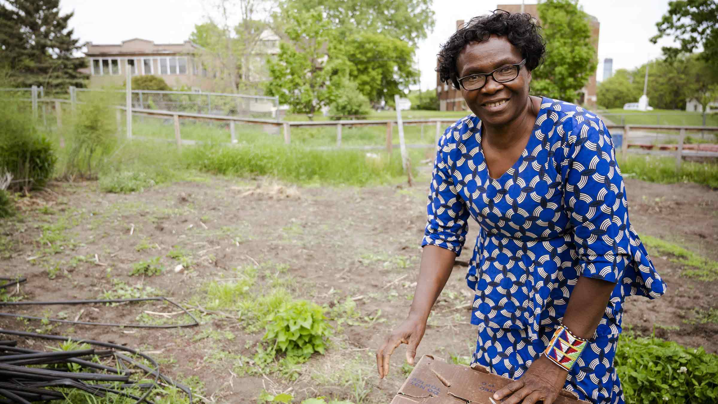 A woman is standing over fresh produce in a field where her crops are