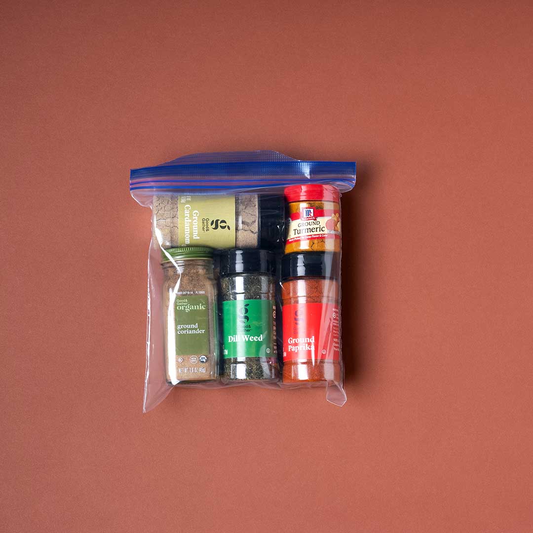 A Ziploc bag is filled with spices familiar to the Afghan community including cardamom, coriander, and dill