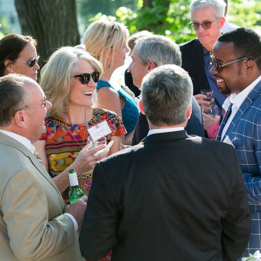 A group of donors stand together networking