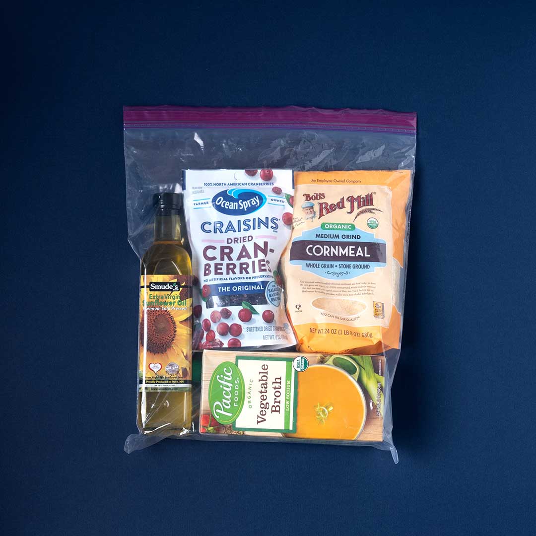 A Ziploc bag is filled with ingredients familiar to the Indigenous community including cranberries, cornmeal, and vegetable broth