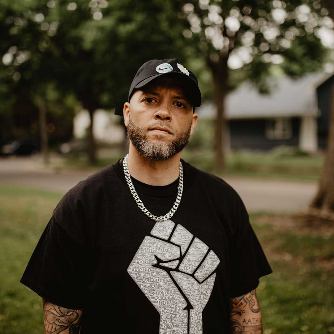 A man stands in a park looking at the camera