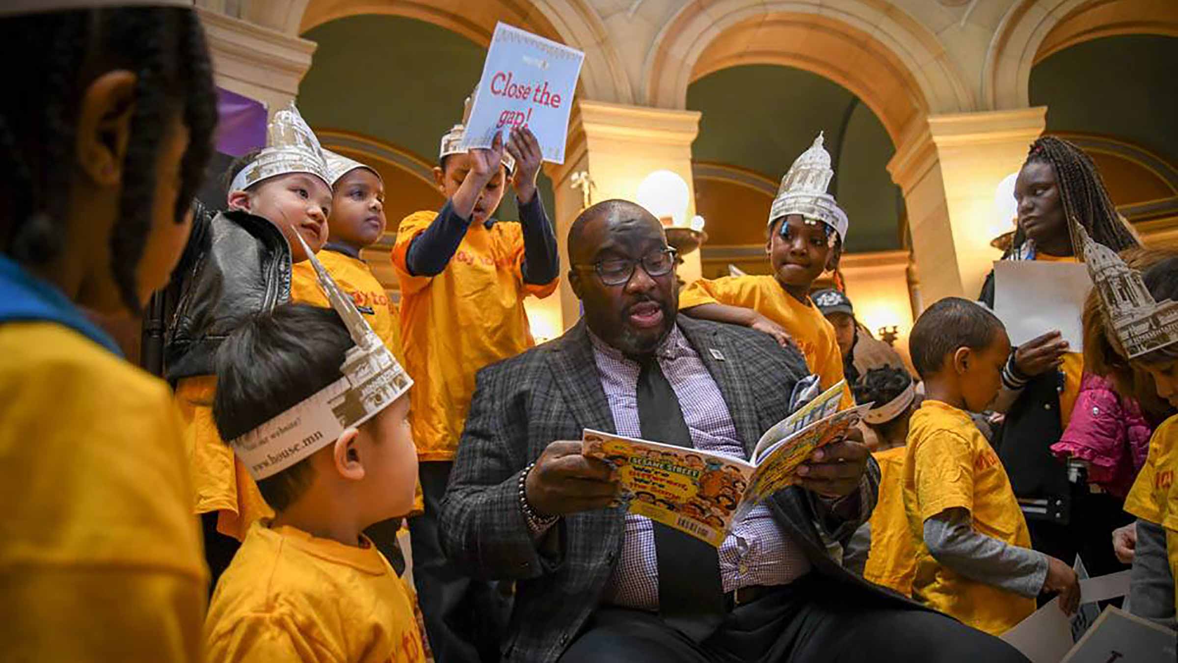 A man reads to a group of children at the Minnesota state capitol building