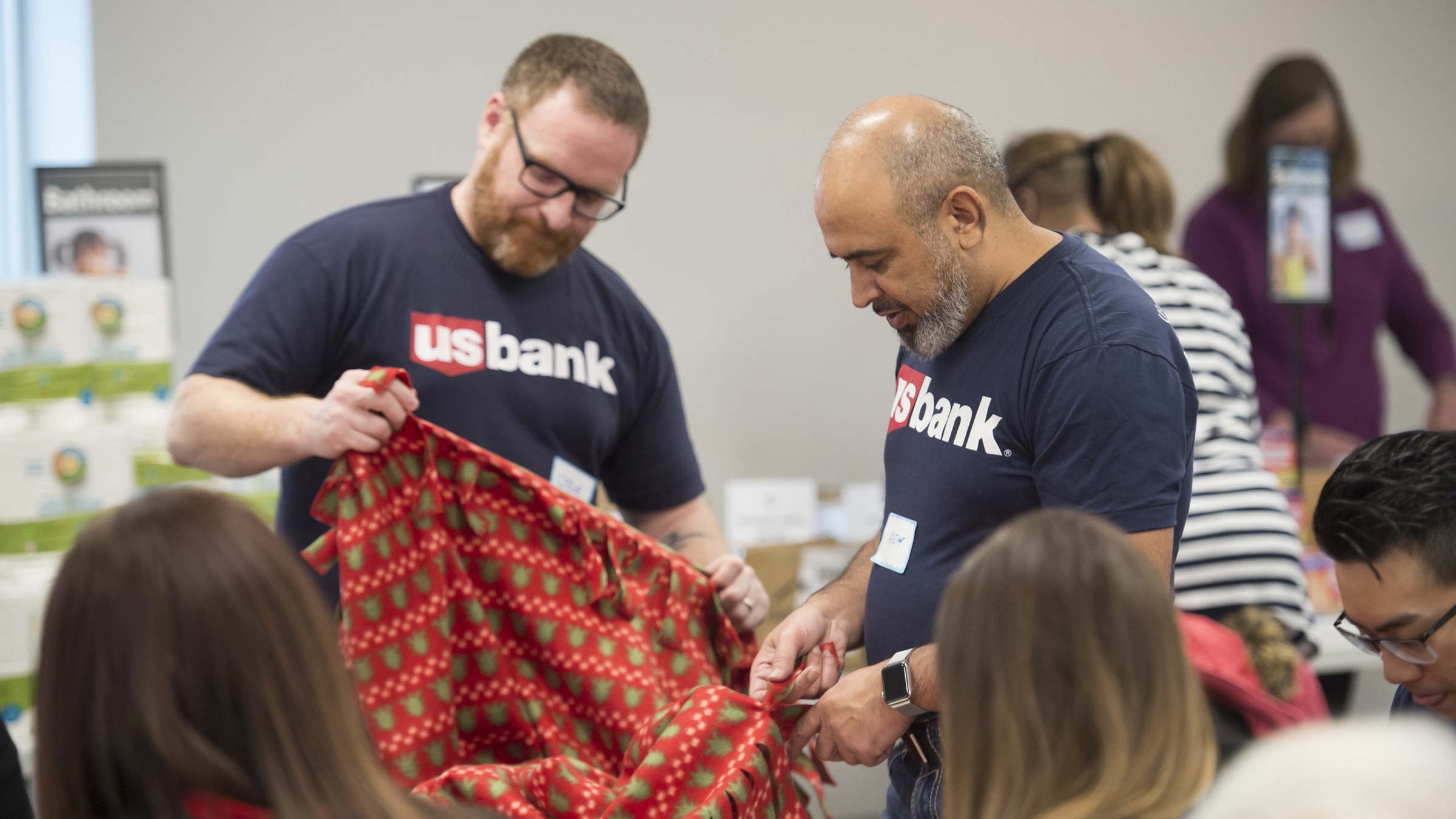 US Bank volunteers are working to tie a blanket