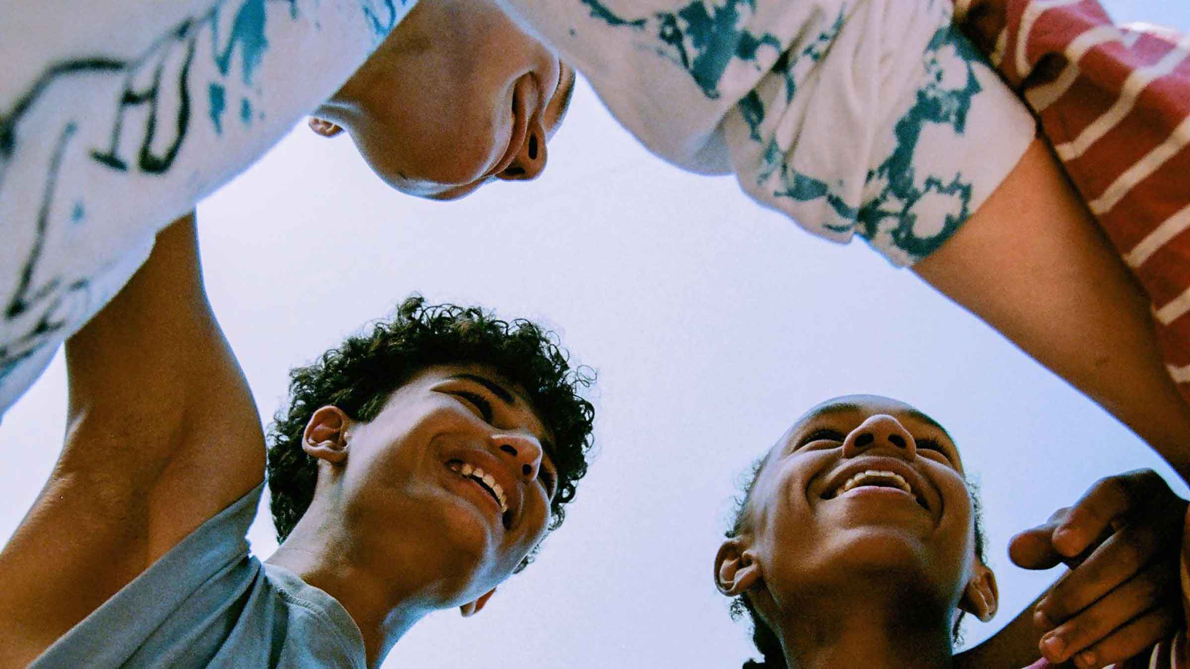 A group of people with linked arms smiling at each other