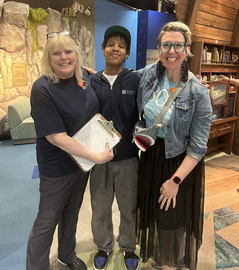 Three people stand together at an 80x3 event