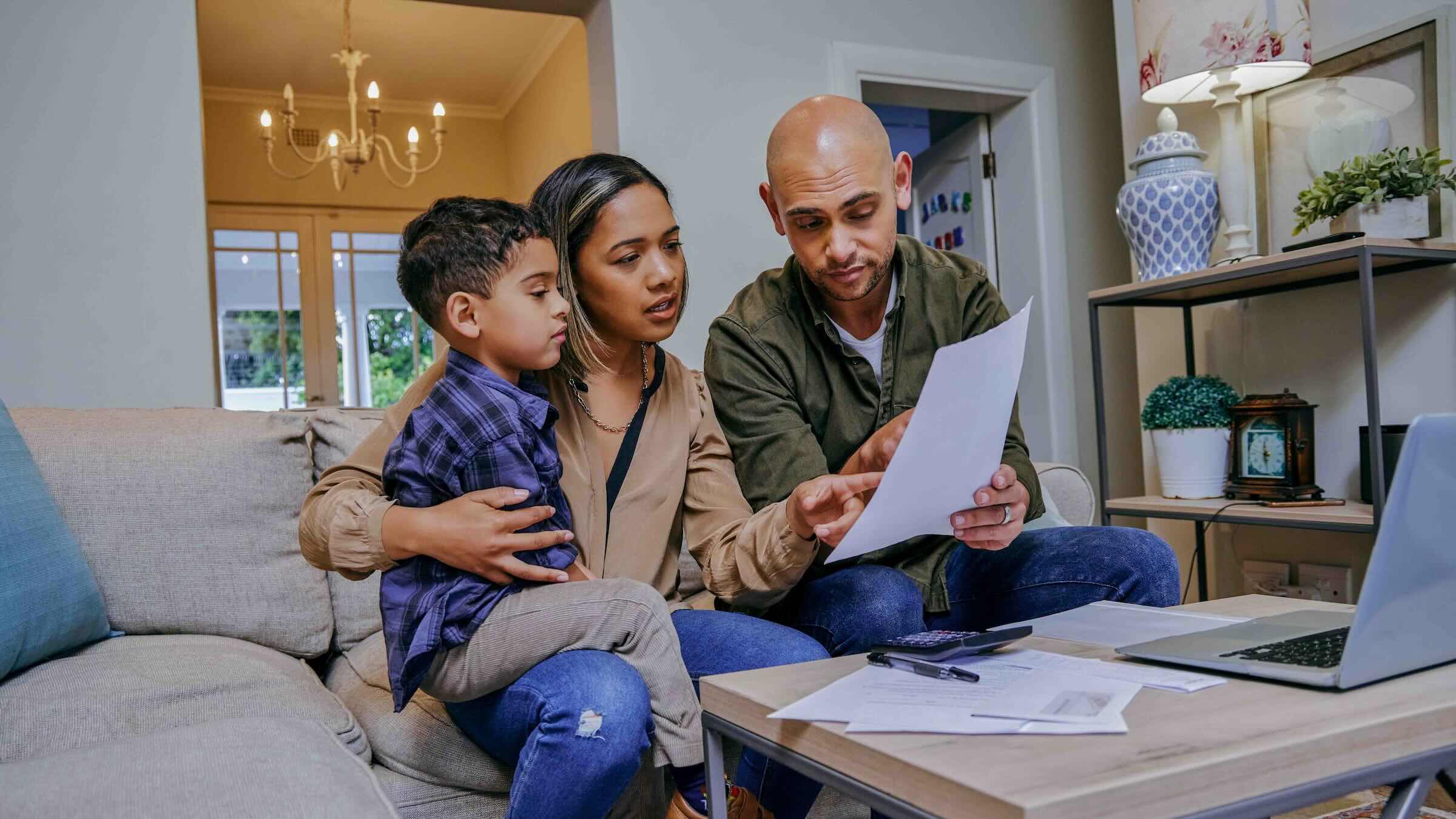 Family reviewing documents while working on a computer.
